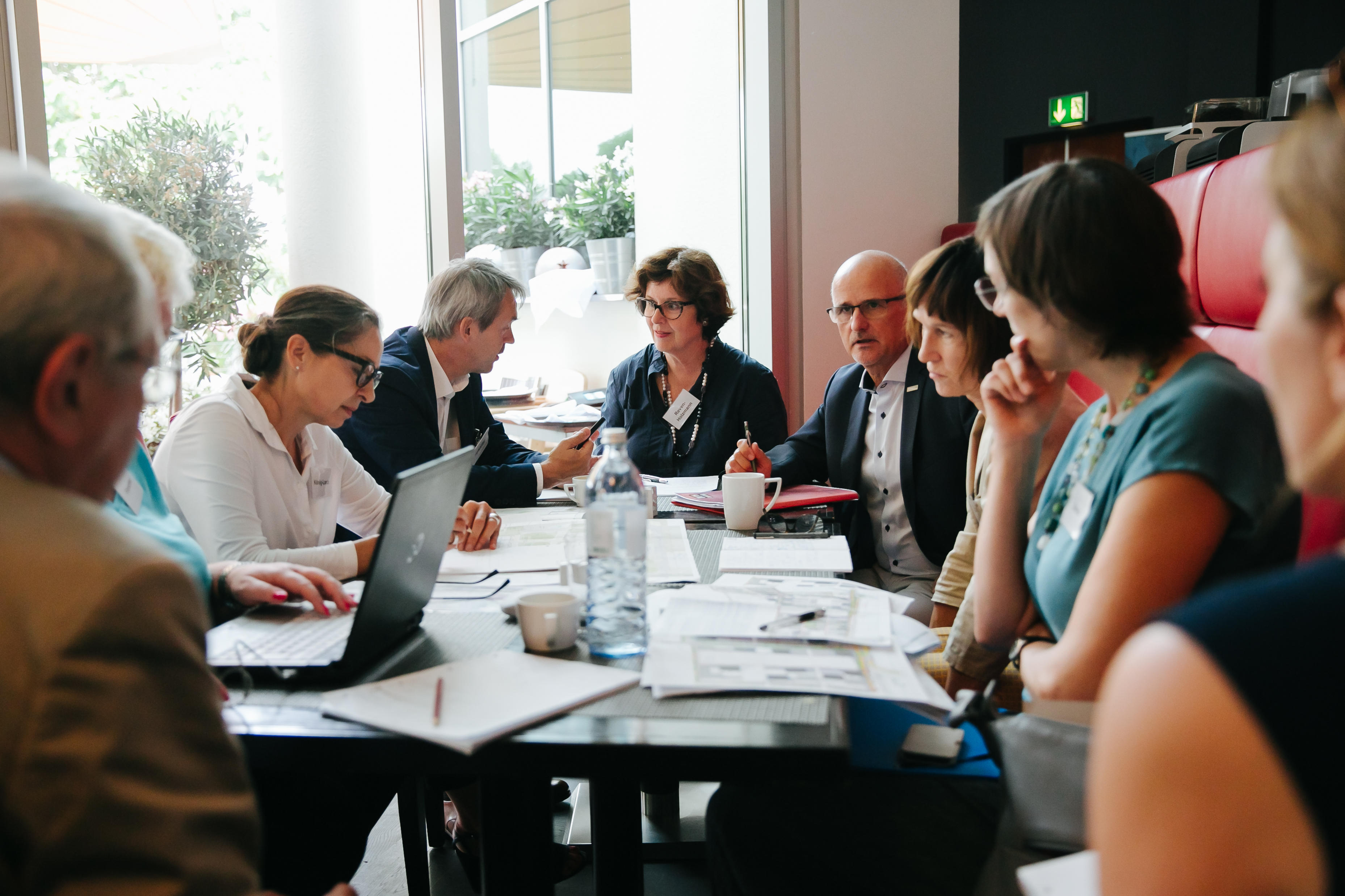 Qualitätsbeitrat sitzt am Besprechungstisch beisammen